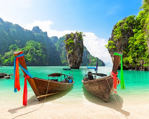 Famous James Bond island near Phuket in Thailand. Travel photo of James Bond island with thai traditional wooden longtail boat and beautiful sand beach in Phang Nga bay, Thailand.
